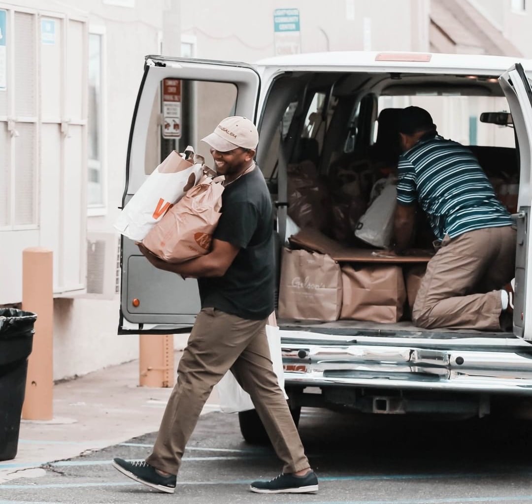 Two people unloading groceries from a van