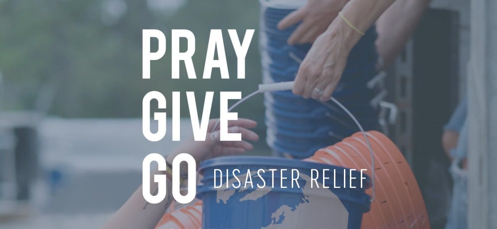 Caption: Pray Give Go Disaster Relief, a person handing another person a bucket